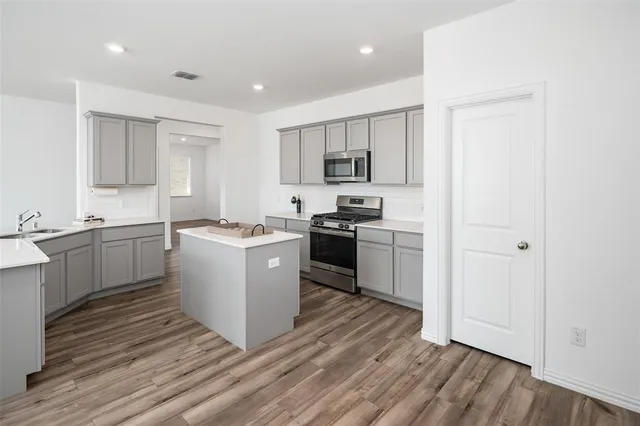 a kitchen with cabinets wooden floor and a sink