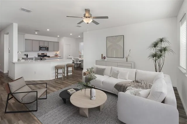 a living room with furniture kitchen view and a chandelier