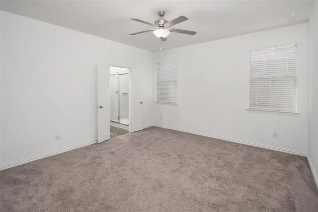 an empty room with a window and a fan