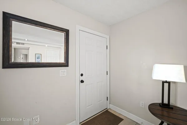 a living room with furniture a flat screen tv and kitchen view