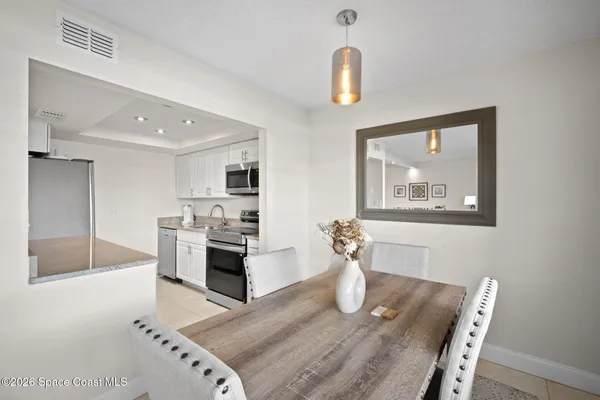 a dining hall with stainless steel appliances granite countertop a stove and a sink