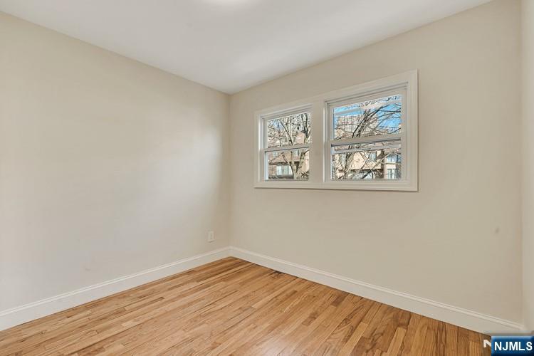 13 Casta Lane, Unit 1 Edgewater, NJ 07020 - Photo 15 of 25 a view of empty room with wooden floor and fan