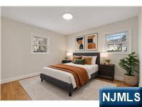 13 Casta Lane, Unit 1 Edgewater, NJ 07020 - Photo 25 of 25 a spacious bedroom with a bed a painting and a potted plant