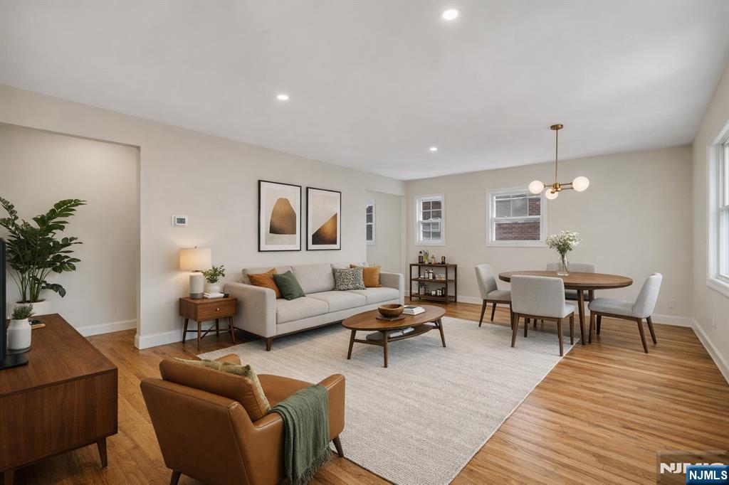 13 Casta Lane, Unit 1 Edgewater, NJ 07020 - Photo 3 of 25 a living room with furniture wooden floor and a chandelier