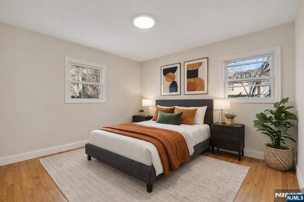 13 Casta Lane, Unit 1 Edgewater, NJ 07020 - Photo 6 of 25 a spacious bedroom with a bed and a potted plant