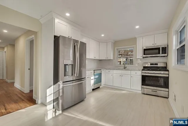 a kitchen with stainless steel appliances a refrigerator stove microwave and cabinets