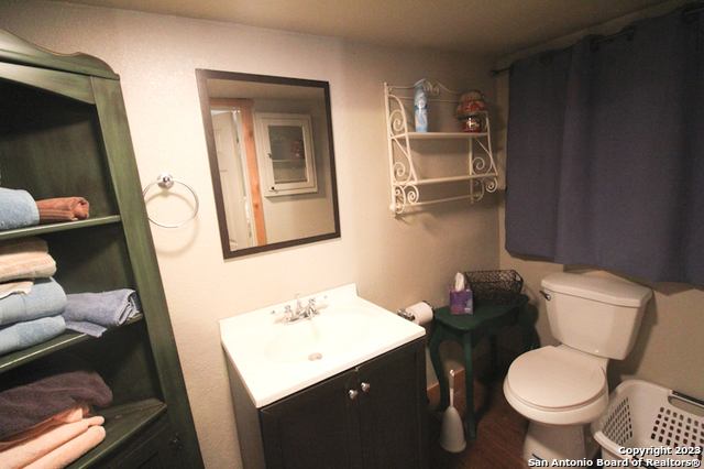 955 Faurie Road, Unit CEDAR CABIN Lakehills, TX 78063 - Photo 14 of 21 a bathroom with a toilet sink and mirror