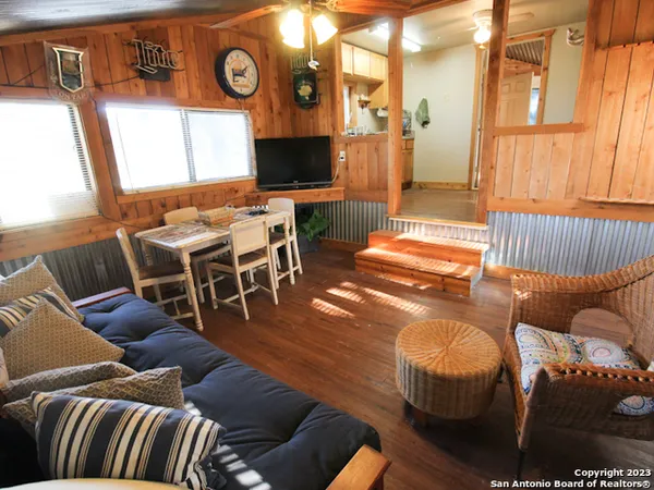 a living room with furniture a flat screen tv and a large window