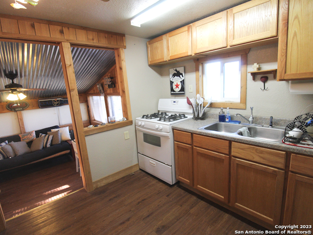 955 Faurie Road, Unit CEDAR CABIN Lakehills, TX 78063 - Photo 8 of 21 a kitchen with a sink cabinets appliances and a window