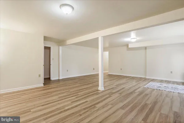 a view of empty room with wooden floor and fireplace