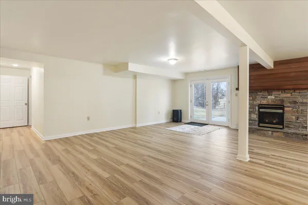 an empty room with wooden floor and fireplace