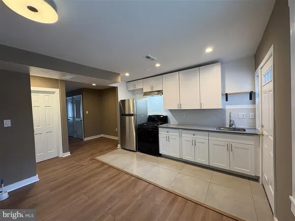 a kitchen with stainless steel appliances granite countertop a refrigerator and a stove top oven