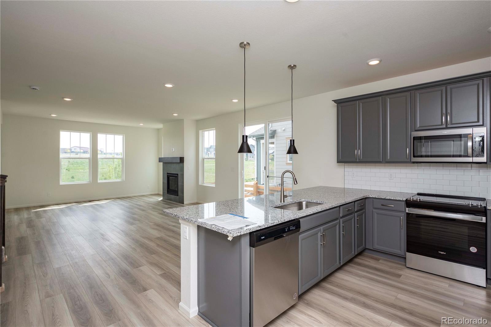 313 Rodden Drive Erie, CO 80516 - Photo 12 of 25 a kitchen with kitchen island granite countertop a sink cabinets and stainless steel appliances