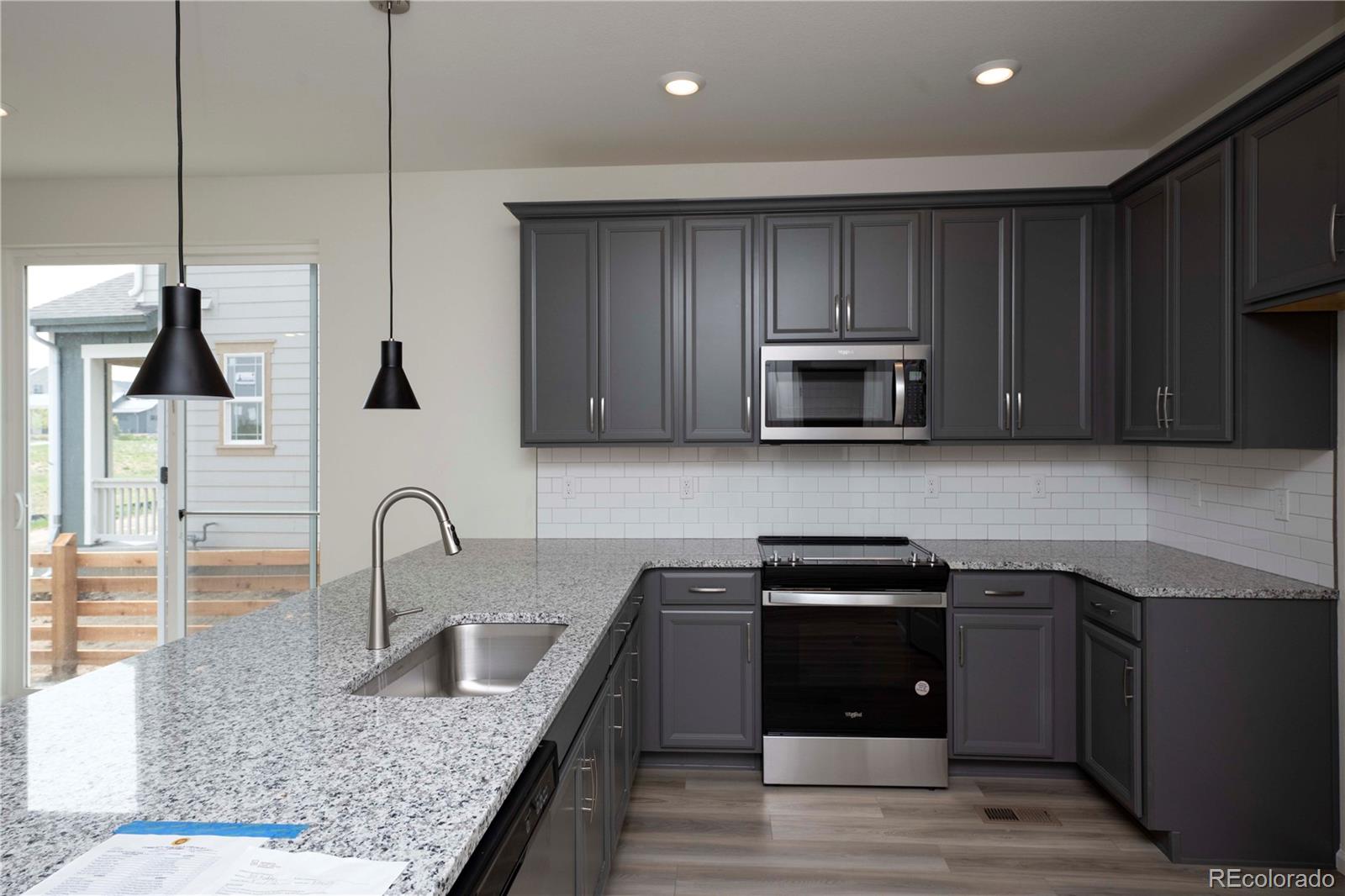 313 Rodden Drive Erie, CO 80516 - Photo 13 of 25 a kitchen with sink a microwave and cabinets