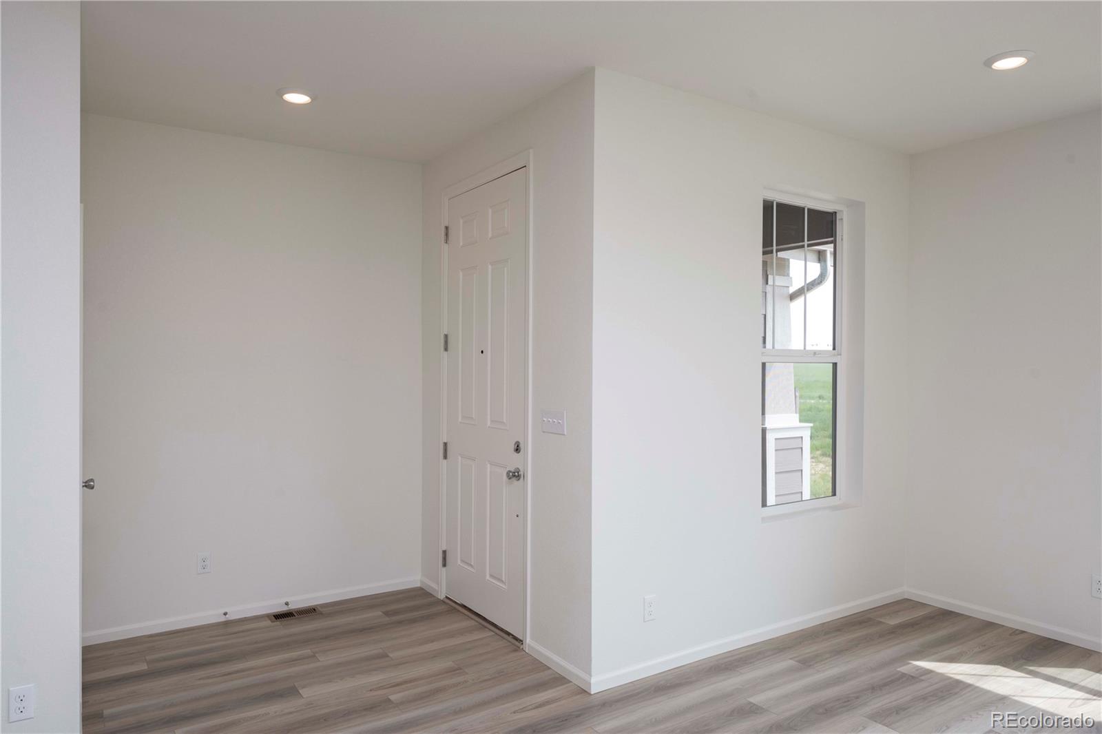 313 Rodden Drive Erie, CO 80516 - Photo 3 of 25 a view of an empty room with wooden floor and a window