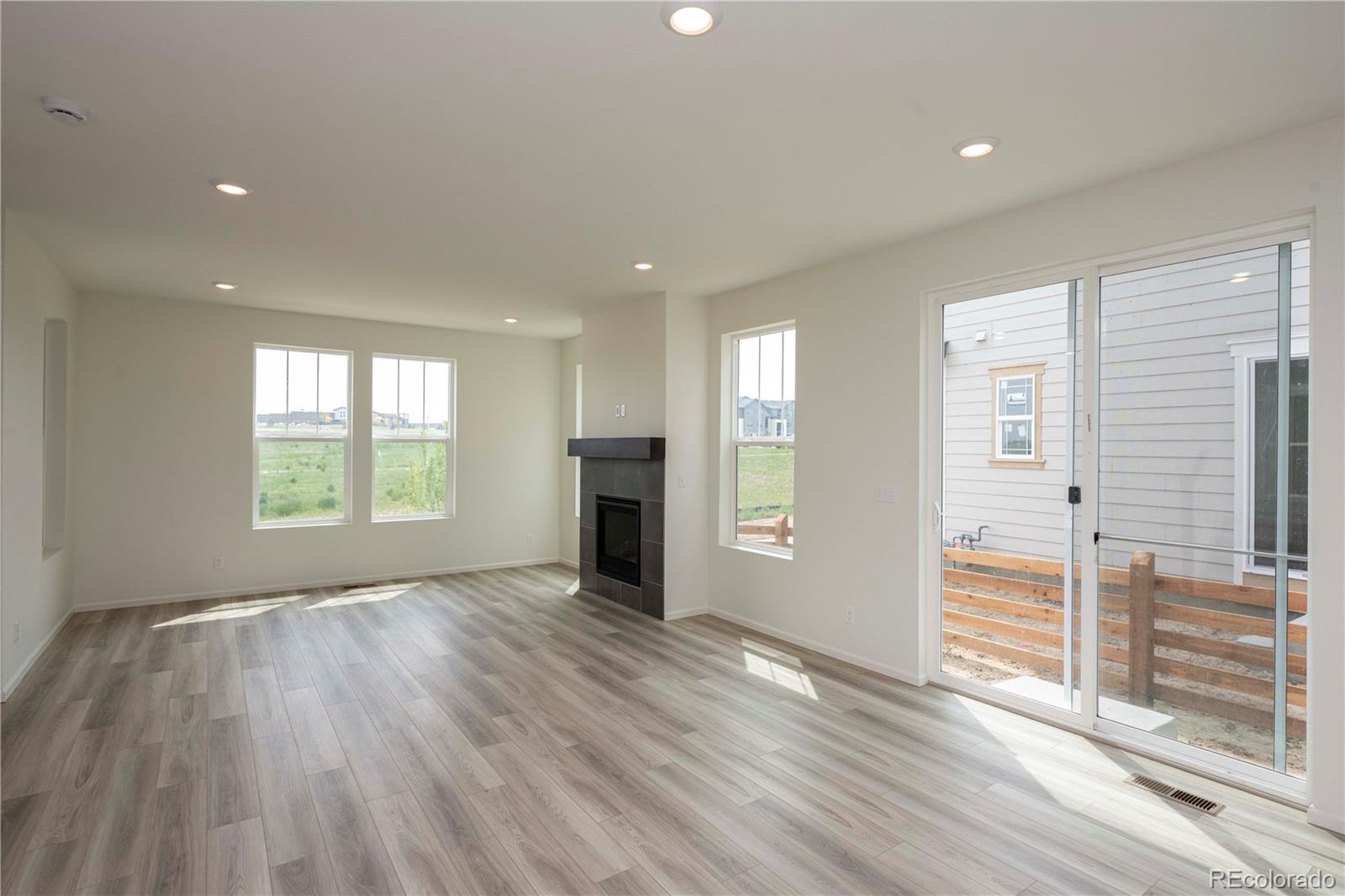 313 Rodden Drive Erie, CO 80516 - Photo 6 of 25 an empty room with wooden floor and windows