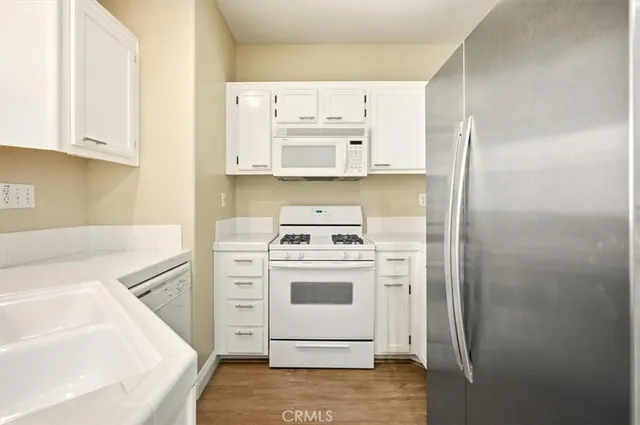 a white refrigerator freezer and a stove sitting inside of a kitchen