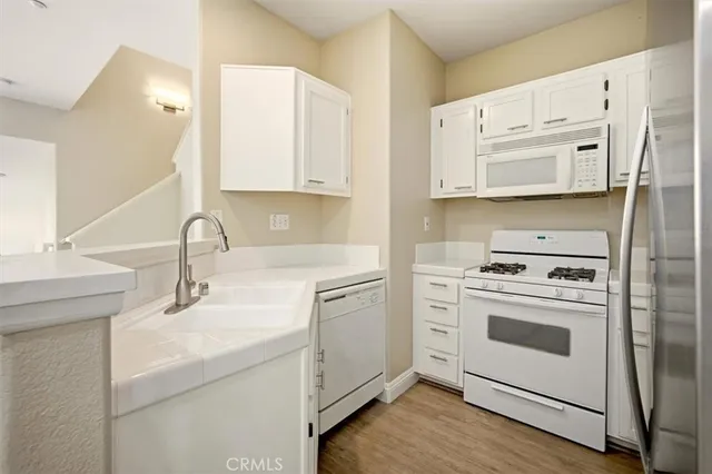 a kitchen with white cabinets and white appliances