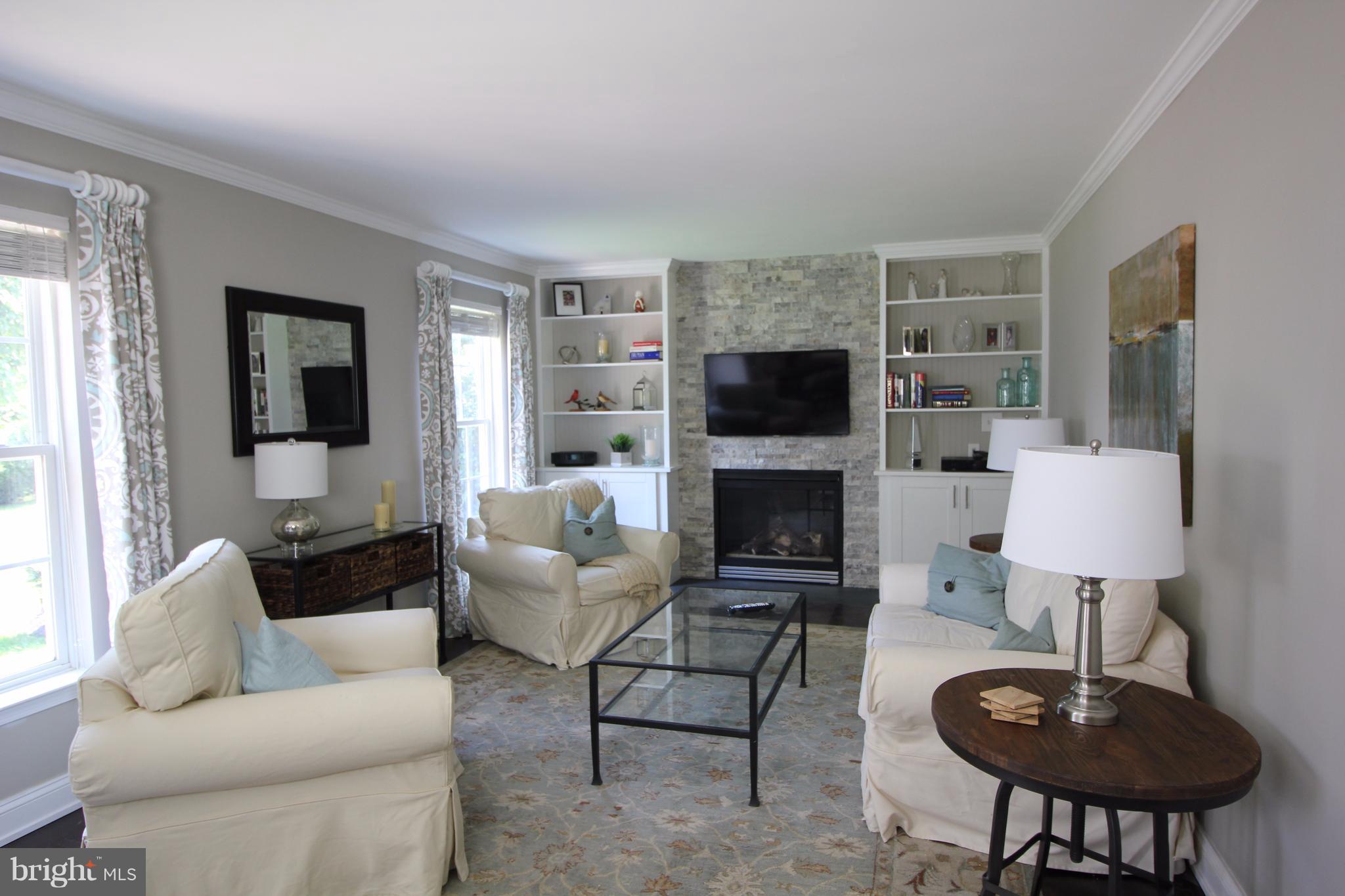 6095 Hanover Road Hanover, MD 21076 - Photo 9 of 30 a living room with furniture a flat screen tv and a fireplace