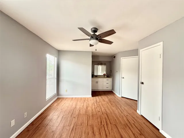 a view of a room with a ceiling fan wooden floor and a ceiling fan