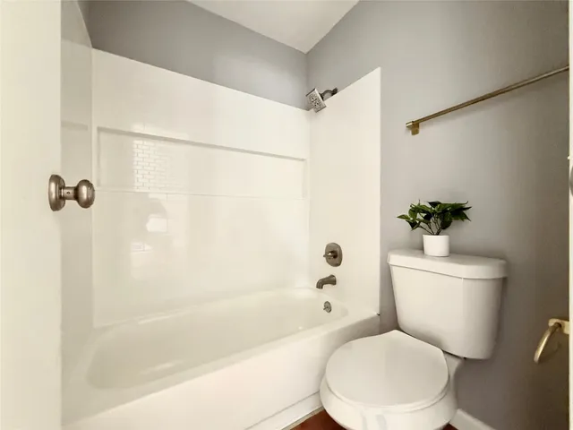 a white toilet sitting next to a bath tub and a shower
