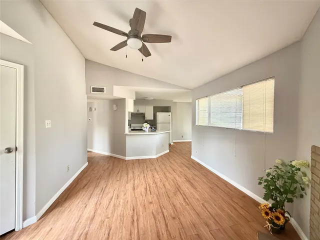 a view of a kitchen with wooden floor electronic appliances and window