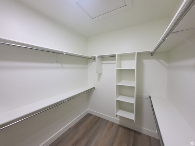 683 Kings Landing Tooele, UT 84074 - Photo 17 of 39 Spacious walk-in closet featuring wood-finish flooring, white shelving, and multiple chrome hanging rods for ample storage