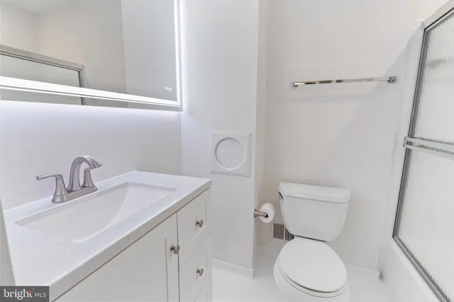 a white toilet sitting next to a bathroom sink