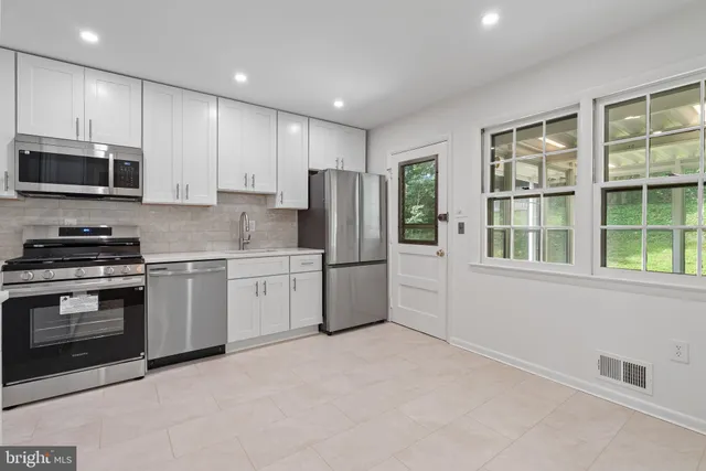 a kitchen with stainless steel appliances granite countertop a stove a sink and a refrigerator