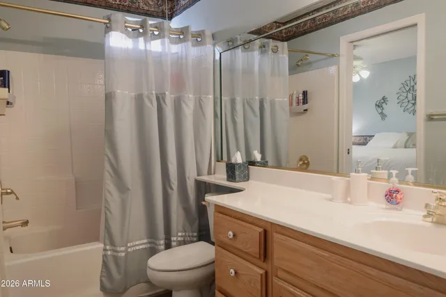 a bathroom with a sink a toilet a mirror and shower