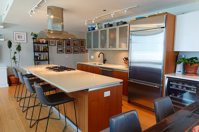 a kitchen with stainless steel appliances a stove a refrigerator and a dining table