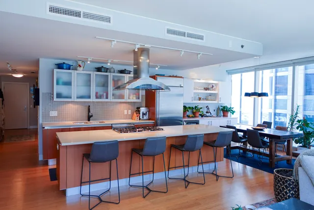 a kitchen with a table chairs stove and wooden floor
