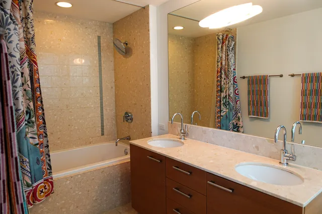 a bathroom with a tub sink shower and a mirror