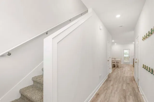 a view of a hallway with wooden floor and staircase
