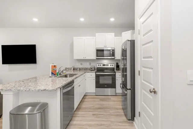 a kitchen with stainless steel appliances a refrigerator stove and microwave