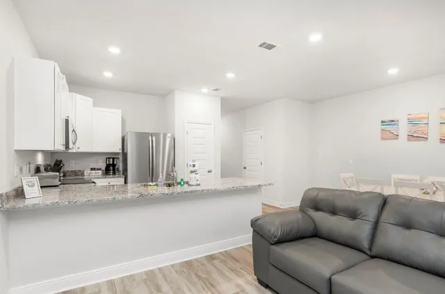 a view of kitchen with stainless steel appliances refrigerator stove microwave and cabinets