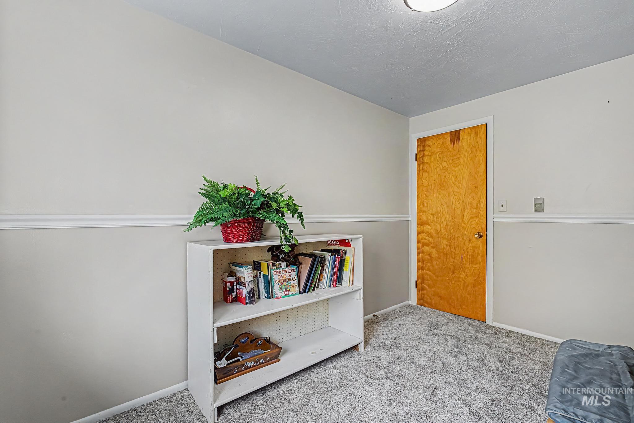 4311 Frozen Dog Road Emmett, ID 83617 - Photo 25 of 31 Room featuring a neutral color palette, wall molding, light wood-finish door, and textured carpeting