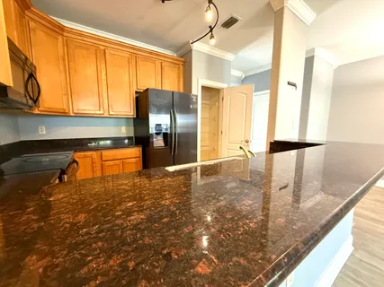 a kitchen with stainless steel appliances granite countertop a sink a stove and a refrigerator