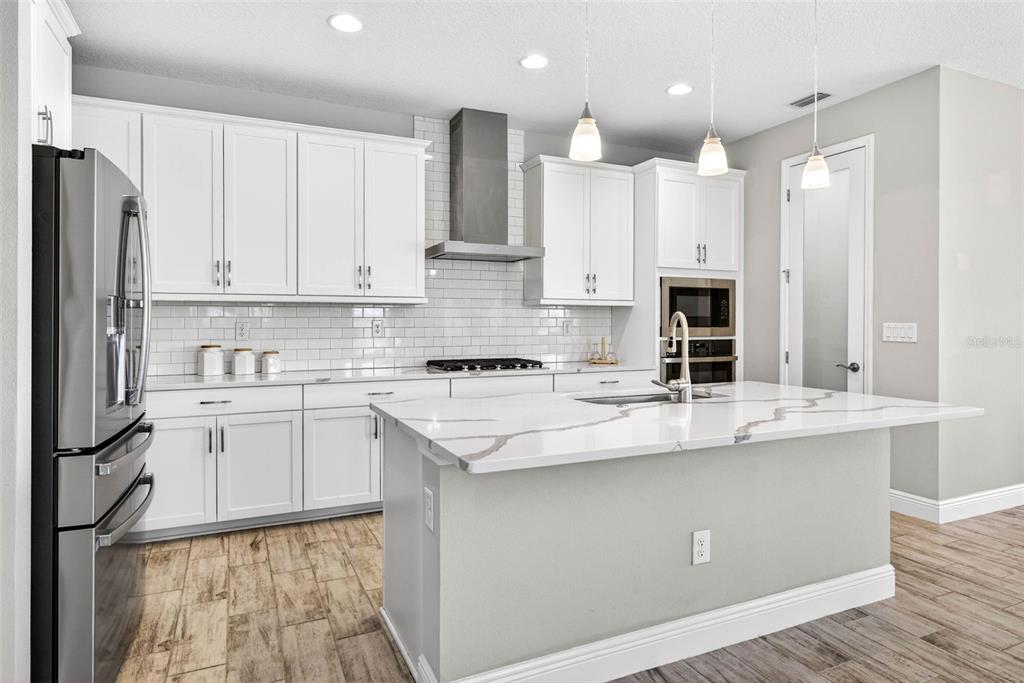 6394 Roadstead Court Apollo Beach, FL 33572 - Photo 12 of 49 a kitchen with kitchen island granite countertop a sink appliances cabinets and counter space