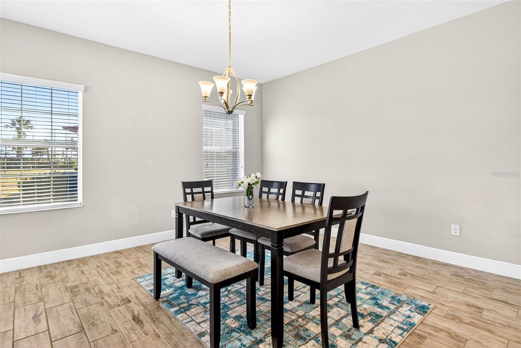 6394 Roadstead Court Apollo Beach, FL 33572 - Photo 18 of 49 a dining room with furniture a chandelier and wooden floor