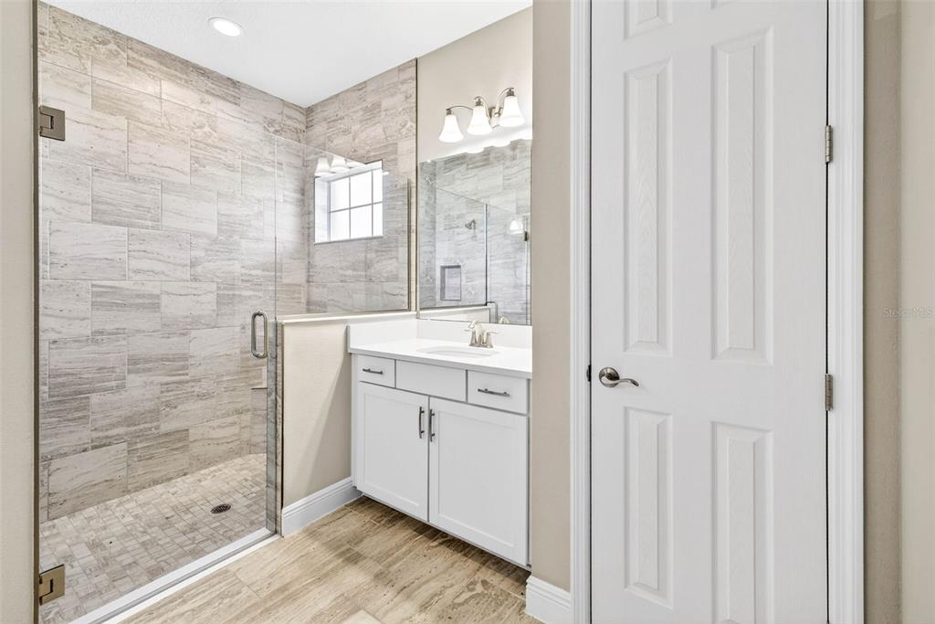 6394 Roadstead Court Apollo Beach, FL 33572 - Photo 22 of 49 a bathroom with a granite countertop sink a mirror and a shower