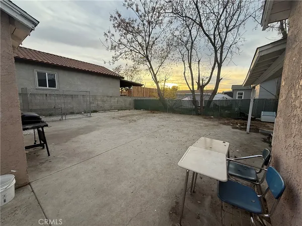 a backyard of a house with table and chairs