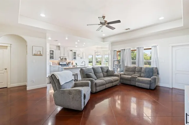 a living room with furniture and a view of kitchen