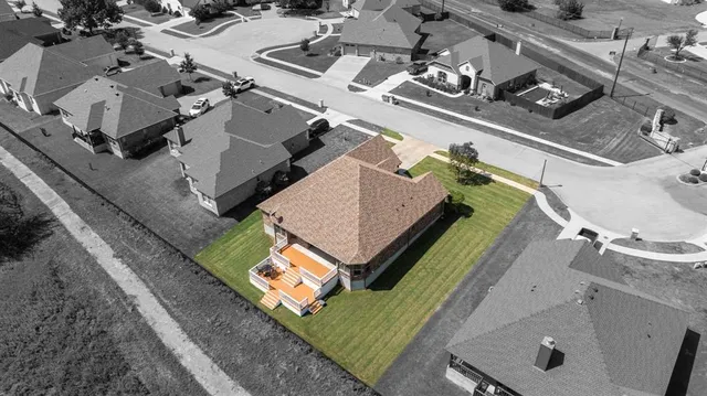 an aerial view of a residential houses with yard