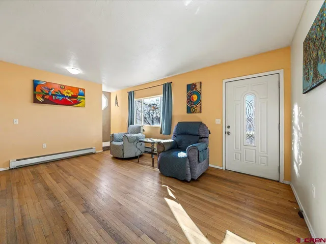 a living room with furniture windows and a wooden floor
