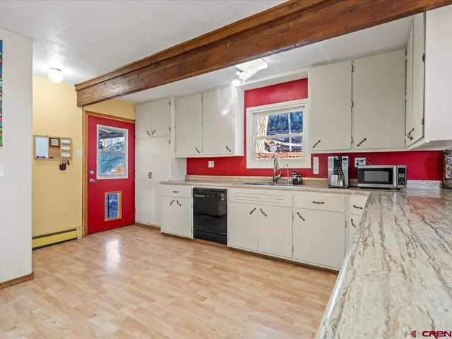 a kitchen with stainless steel appliances granite countertop a sink dishwasher and cabinets with wooden floor