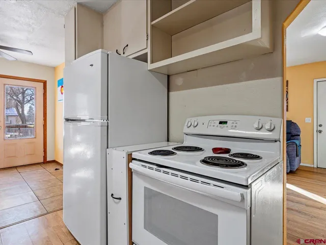 a white refrigerator freezer and a stove sitting inside of a kitchen