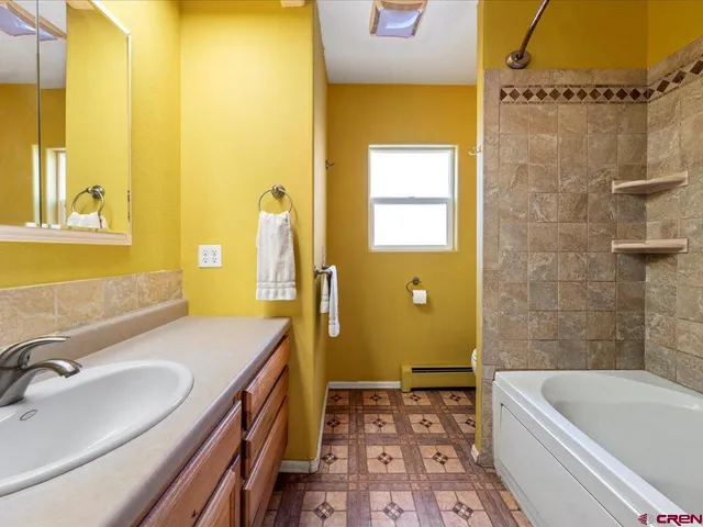 a bathroom with a tub sink and mirror