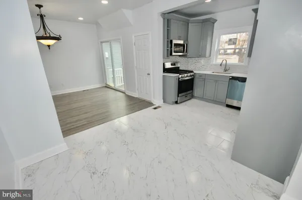 a view of a kitchen with a sink dishwasher and wooden floor