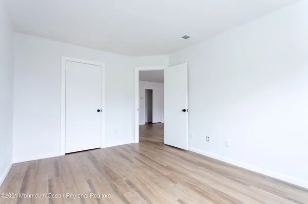 a view of an empty room with wooden floor